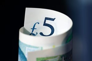 selective focus photography of rolled 5 banknote